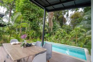 a dining room with a table and a swimming pool at Anusara Dream Villa with Pool & AC in Talamanca