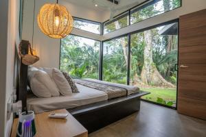 a bedroom with a bed and a large window at Anusara Dream Villa with Pool & AC in Talamanca