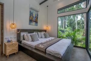 a bedroom with a bed and a large window at Anusara Dream Villa with Pool & AC in Talamanca