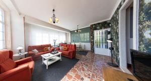 a living room with red couches and a tv at Luxury Singular Rosa in Padrón