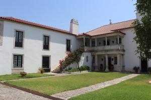una grande casa bianca con un cortile erboso di Quinta do Regalo a Coimbra