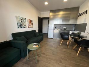 Una sala de estar con un sofá verde y una cocina. en Vake apartment, en Tiflis