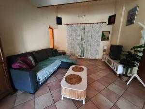 un salon avec un canapé et une télévision dans l'établissement Chambre vue jardin rez-de-chaussée, à Millas