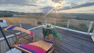 a deck with two chairs and a table and an umbrella at Parthenope in Petacciato