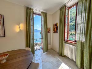 a dining room with a table and large windows at Giulia in Dongo