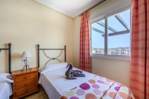 un dormitorio con una cama y una ventana en AlmeriaSuite Vera Terrace & Pool, en Media Legua 23 fotos más