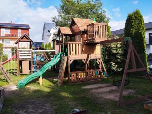 a playground with a tree house and a slide at Best in Karwia