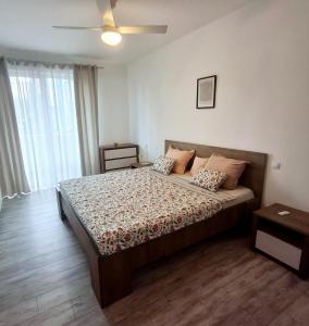 a bedroom with a bed and a ceiling fan at YamaLuxe Apartments - Modern & Cozy in Cluj-Napoca
