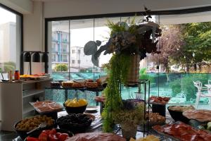 un buffet de nourriture dans une pièce avec une grande fenêtre dans l'établissement Vila Maria, à Eforie Nord 7 autres photos