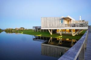 a house on the water with a dock at Casa de Lujo Frente al Mar - Chacra Lobos de Mar in Nueva Atlantis