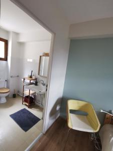 a bathroom with a yellow chair and a sink at Auberge et Gites de Sauze in Sauze