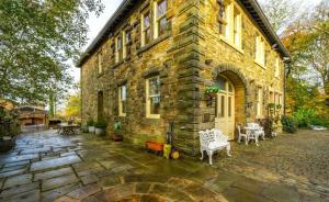 a large stone building with a stone patio in front of it at Fitzys Coach House - Wellness Retreat 