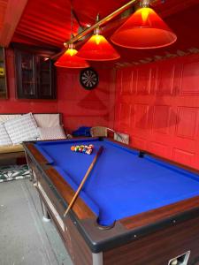 a pool table in a room with red walls at Fitzys Coach House - Wellness Retreat 