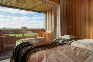 two beds in a room with a large window at Casa de Lujo Frente al Mar - Chacra Lobos de Mar in Nueva Atlantis +94 photos