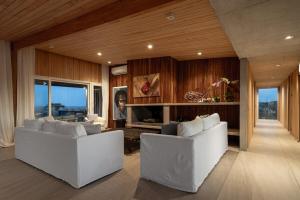 a living room with two white couches and a fireplace at Casa de Lujo Frente al Mar - Chacra Lobos de Mar in Nueva Atlantis