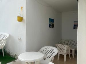 Habitación con mesa, sillas y mesa y sillas blancas. en Lovely family Apartment in Cabo CaboNegro, Bella Vista, en Cabo Negro