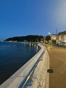 a road next to a body of water at Tides Reach Guest House in The Mumbles