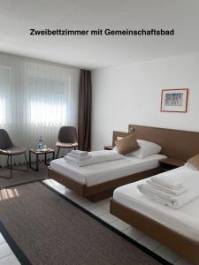 a hotel room with two beds and a table and chairs at Elha Hotel in Stuttgart +55 photos