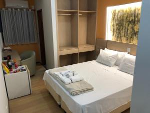 Un dormitorio con una cama con toallas. en Hotel & Restaurante Paraíso Ponte Nova - Ponte Nova - MG, en Ponte Nova