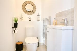 un bagno bianco con un water e un lavandino di Harveys Yard by Signature Stays - Hayle Luxury Beach home with parking - sleeps 6 a Hayle Altre 23 foto