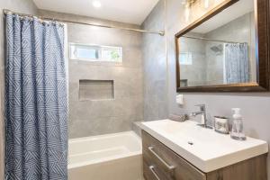 a bathroom with a sink and a shower curtain at Magnificent House Minutes From Hollywood in Los Angeles +8 photos
