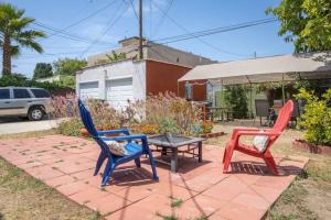 three colorful chairs and a table on a patio at Magnificent House Minutes From Hollywood in Los Angeles