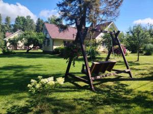 a swing in a yard with a house at Katase Puhkemaja in Katase