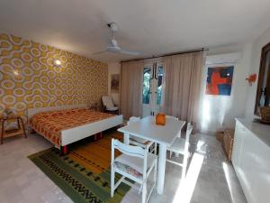 een slaapkamer met een bed, een tafel en stoelen bij Dammusino A-mare in Pantelleria