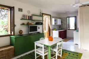 een woonkamer met een tafel en een keuken bij Dammusino A-mare in Pantelleria
