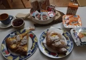 a table with plates of food and cups of coffee at La Bouganville in Macerata +14 photos
