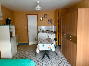 een kleine keuken met een kleine tafel en een kleine keuken met een tafel bij Les Logis du Haut-Folin in Arleuf +6 foto's