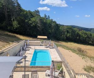 a swimming pool on the side of a hill at Domaine de Fleurie in Tursac