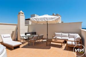 a patio with a table and chairs and an umbrella at Casa Fina in Estepona