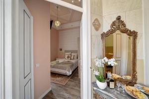 une chambre avec un lit et un miroir dans l'établissement Vintage Senses Residences, à Faro