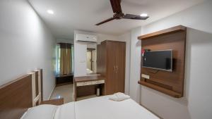 a bedroom with a bed and a tv on a wall at Lilly Ribera in Kumarakom +26 photos