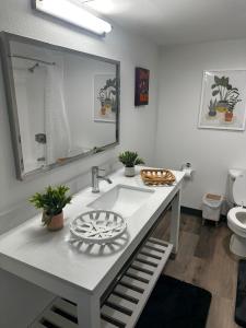 a white bathroom with a sink and a mirror at Cozy Studio in Houston