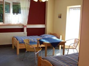 a room with two beds and a table and chairs at Econo Motel Goelzer in Büchenbeuren