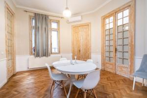 a dining room with a white table and chairs at Lascăr Catargiu Villa in Bucharest
