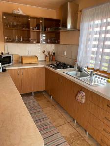 a kitchen with wooden cabinets and a sink at Ambrus vendégház in Gheorgheni