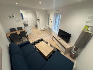 a living room with a blue couch and a table at Maison Merveilles 4 in Saint Malo