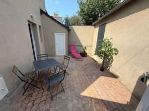 a patio with a table and chairs next to a building at Maison Merveilles 4 in Saint Malo +3 photos