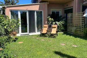 two chairs sitting in the grass in front of a house at Charming Retreat in Mesochórion +1 photo