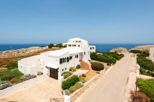una casa bianca con l'oceano sullo sfondo di Villa Lira a Cala Morell