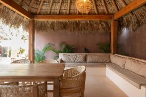 a patio with a couch and a table and chairs at Casa Moka in Puerto Escondido