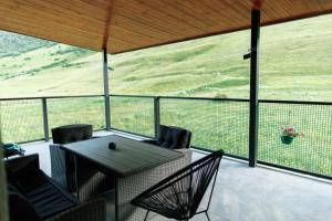 a patio with a table and chairs on a balcony at Kazbegi Estate in Kazbegi