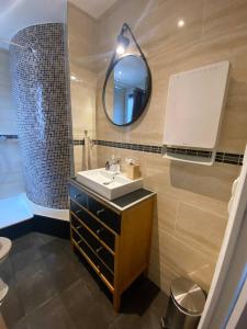 a bathroom with a sink and a mirror at Appartement Gratte-Ciel 4p Chek in H24 in Villeurbanne