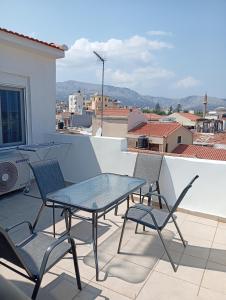 a patio with a table and chairs on a balcony at Tourni Cozy Chios in Chios