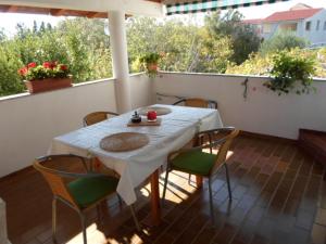 a table and chairs on the back porch of a house at Studio apartman Kata Nin in Nin