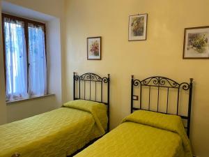a bedroom with two beds and a window at Appartamento La Clessidra in Roccatederighi