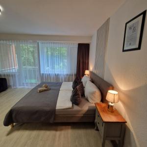 a bedroom with a bed with a teddy bear on it at RELAX INN - Messe contactless check in in Hannover +19 photos